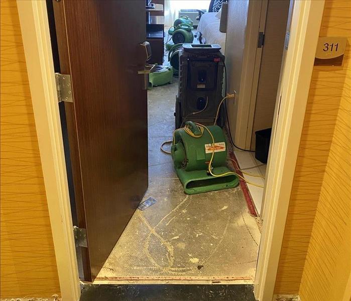 servpro fans in ripped out carpet hotel bedroom