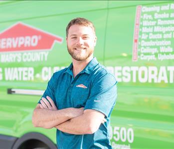 headshot in black servpro polo, male employee in front of green vehicle